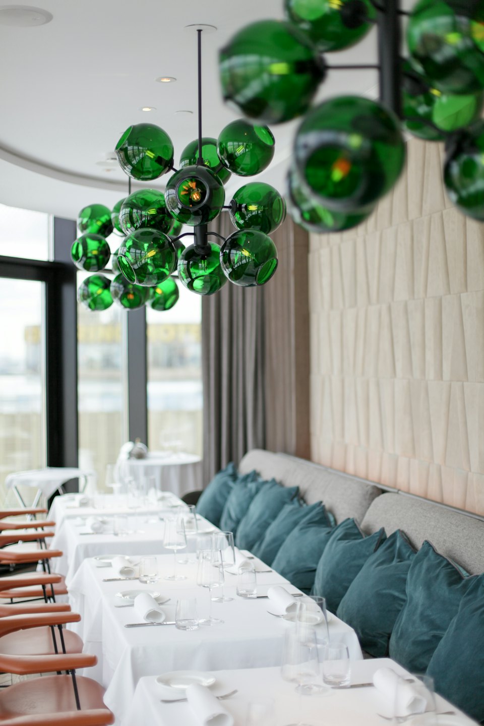 Modern restaurant dining room with green glass chandelier.