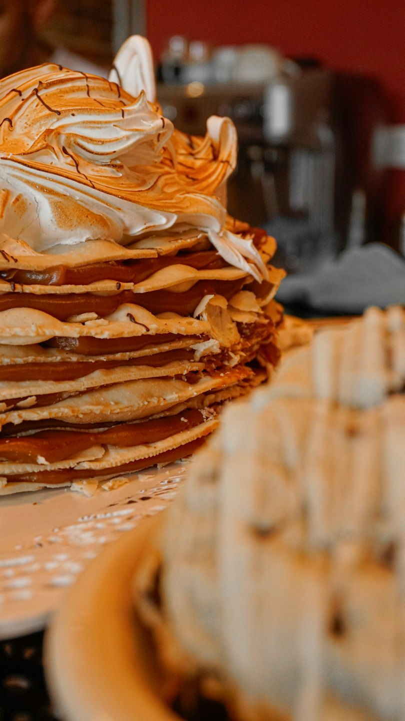 Layered pastry topped with toasted meringue and chocolate drizzle.