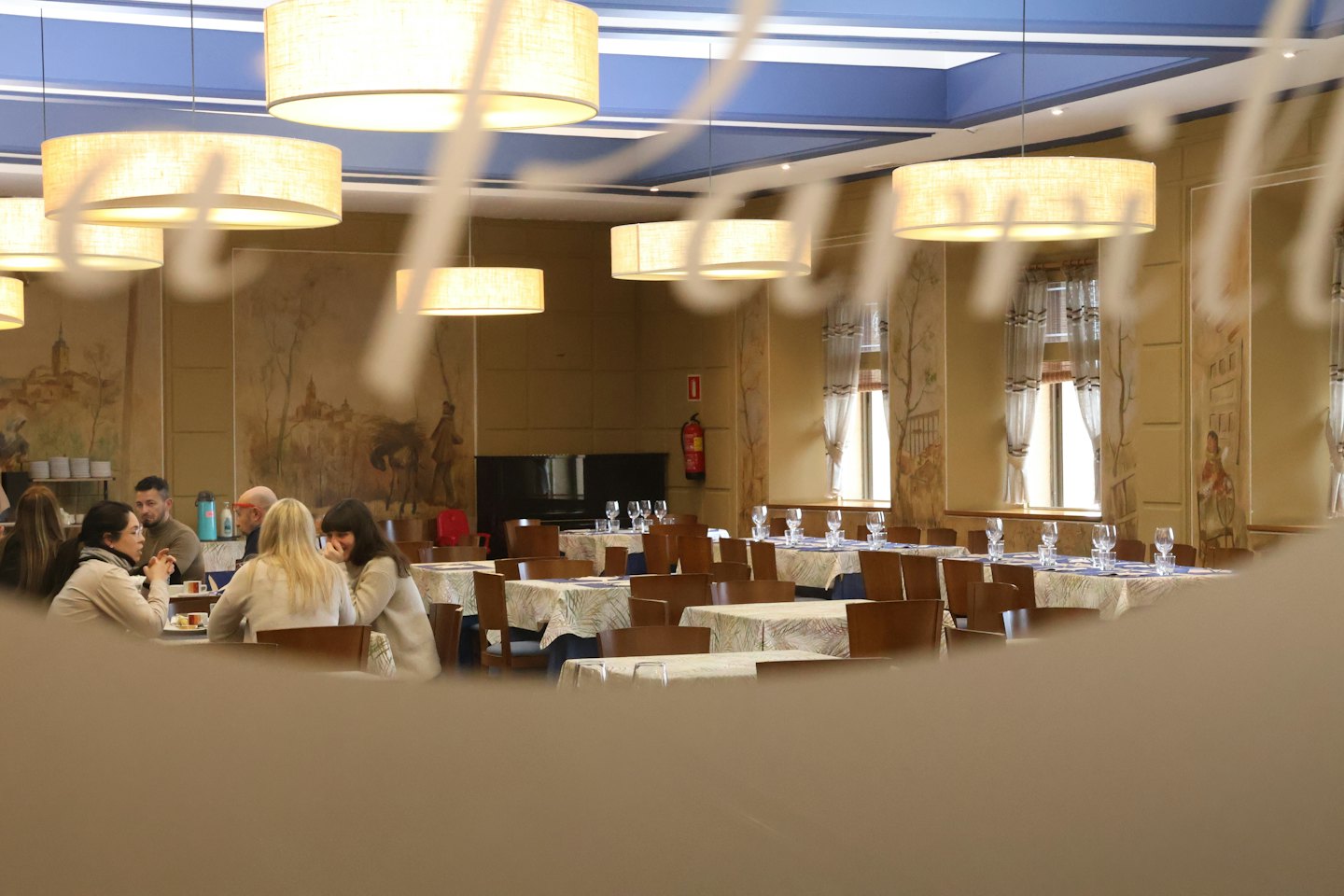 People conversing at a dining table in a traditional restaurant.
